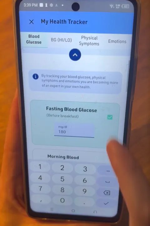 Närbild på mobilskärm med en app där blodsockervärden förs in