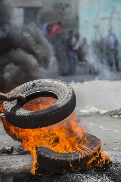 En demonstrant bränner däck i Port-au-Prince