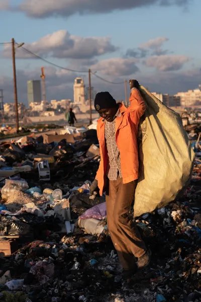 En man samlar skrot på en sopptipp i Libyen.