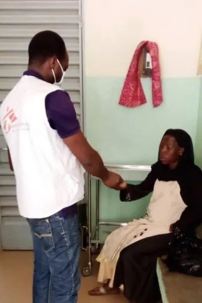 En anställd från Läkare Utan Gränser hälsar på en patient vid vårdcentralen i Fada, östra Burkina Faso.