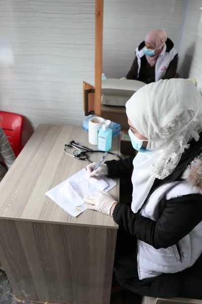 En sjuksköterska konsulterar med en ung pojke i nordvästra Syrien