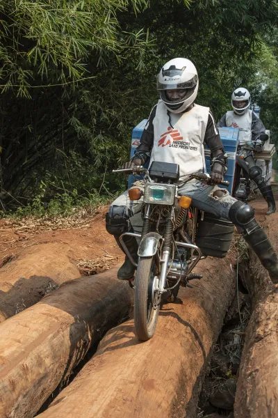 Sjukvårdspersonal på motorcyklar på en lerväg
