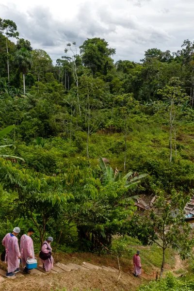 Personal påväg till båtar för transport i Amazonas regnskog