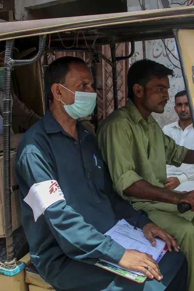 Hälsoinformatören Munir Hussain delar ut munskydd i Karachi, Pakistan, för att stoppa spridningen av covid-19.
