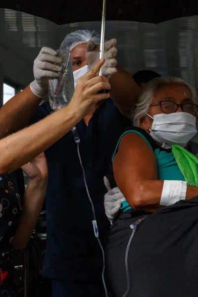 En kvinna med covid-19 bärs till ambulans för vidare transport till flygplatsen och därifrån till sjukhuset i Manaus, Brasilien. 