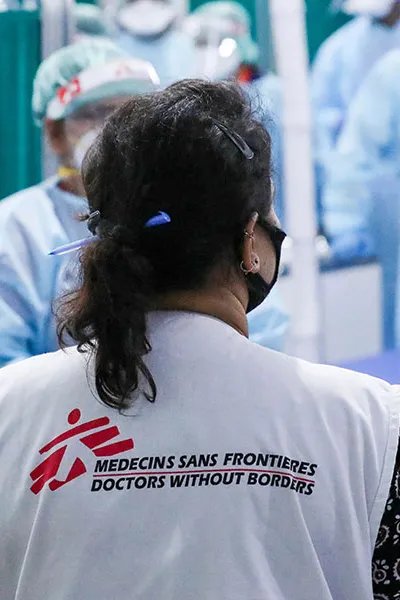 Läkaren Nisha Mohan står med ryggen mot kameran och pratar med personal på vårt  temporärt sjukhus i Patna, Indien.