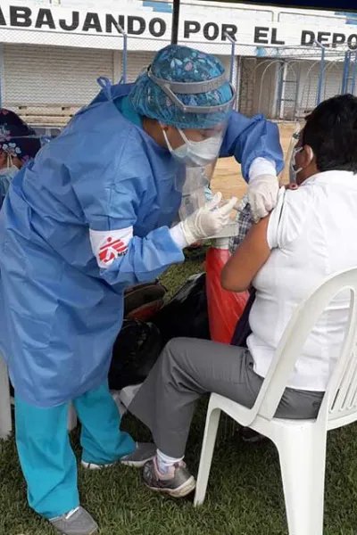 Personal från Läkare Utan Gränser vaccinerar en kvinna i Peru mot covid-19.