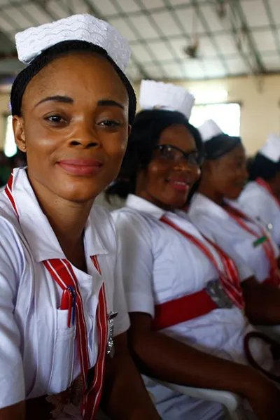 Sjuksköterskor och barnmorskor sitter på rad vid en examensceremoni i Sierra Leone.