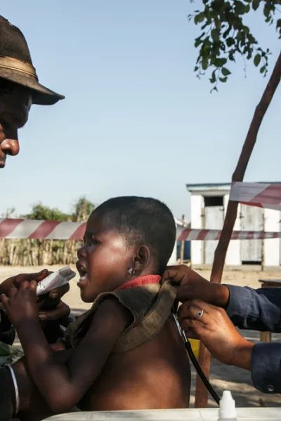 En man ger ett näringsberikat kex till sin femåriga dotter som är undernärd. Samtidigt undersöker en kvinnlig läkare barnet med ett stetoskop. Undersökningen sker under bar himmel i södra Madagascar.