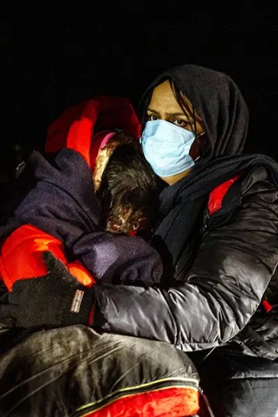 En mamma från Irak kramar sina döttrar, någonstans vid gränsen mellan Polen och Belarus