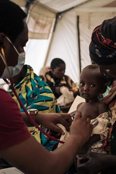 Läkaren Benjamin Safari undersöker elva månader gamla Emeriane i i flyktinglägret i Rhoe, Kongo-Kinshasa.