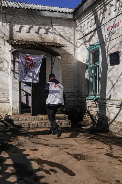 En anställd från Läkare Utan Gränser går in i ett hus i byn Starohnativka, Ukraina.