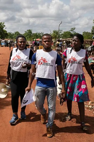 Tre hälsoinformatörer från Läkare Utan Gränser går på en gata i delstaten Ebonyi i sydöstra Nigeria.