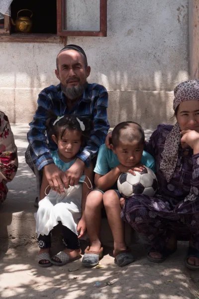 Surayo sitter med sina barn, sina föräldrar och en brorson på trappan framför deras hus i västra Tadzjikistan.
