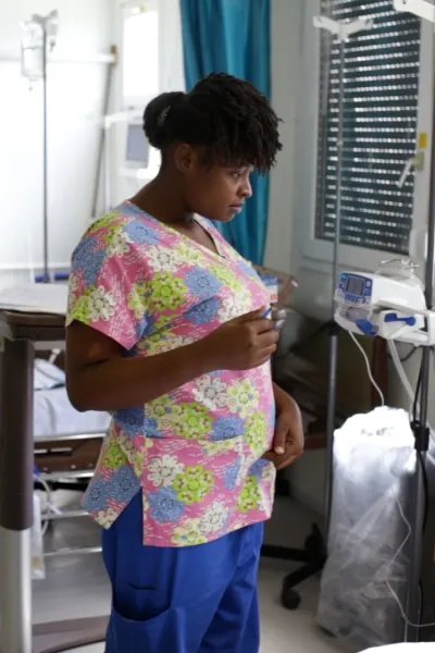 Sjuksköterskan Gessica i Haiti talar med en patient som ligger i en sjukhussäng