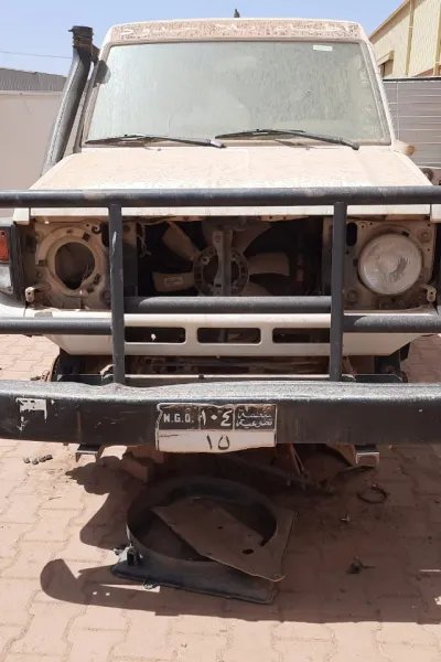 en bil utan däck och andra delar står vid ett av Läkare Utan Gränsers lager i Khartoum, Sudan