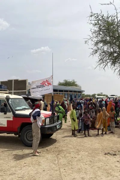 jeepar och människor i ett flyktingläger för sudaneser i Tchad