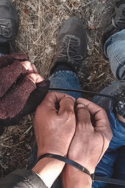 Närbild på flera par smutsiga händer som är ihopbundna med buntband