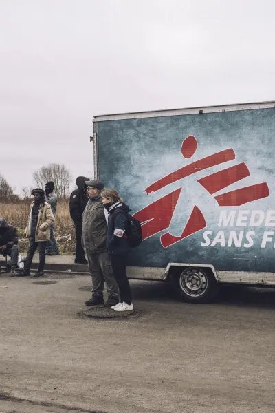 Människor väntar utanför Läkare Utan Gränsers mobila klinik i Calais.