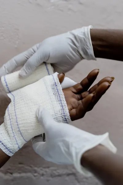 Två händer syns, en hand får bandage.