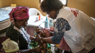 Ellen från Läkare Utan Gränser besöker ett barn som visar symptom på malaria.