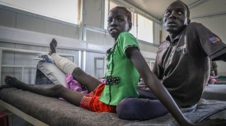 En flicka på en sjukhussäng med ett bandagerat ben