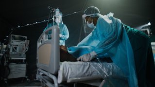 En patient som ligger i en sjukhussäng får vård.