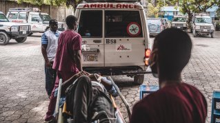 En man på bår bärs in i Läkare Utan Gränsers ambulans. 