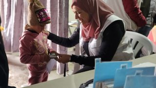 Vårdpersonal mäter syremättnaden på ett barn.