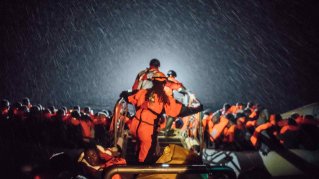Besättningen på  Aquarius undsätter flyktingar från en gummibåt utanför Libyens kust.