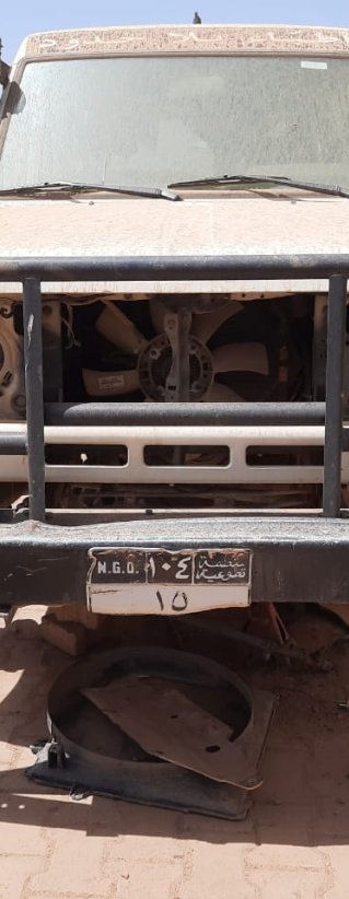 en bil utan däck och andra delar står vid ett av Läkare Utan Gränsers lager i Khartoum, Sudan
