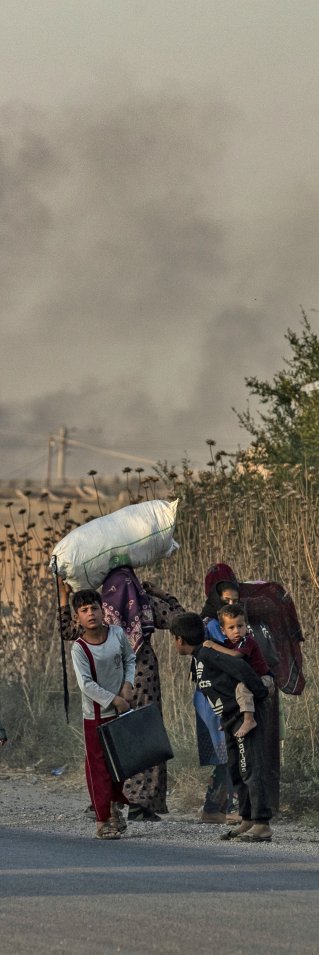 Kvinnor och barn på en väg med mycket packning
