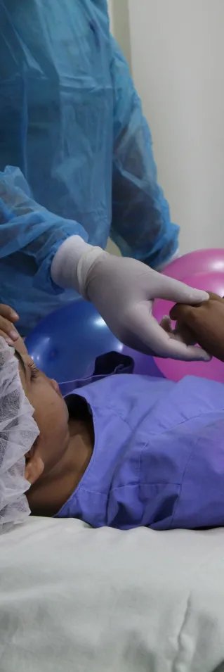 Salwa ligger på en bår med ballonger på sig