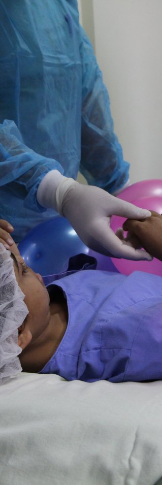 Salwa ligger på en bår med ballonger på sig