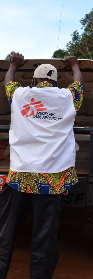 En man kollar under huven på en bil