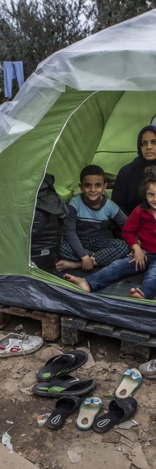En familj sitter i sitt tält utanför flyktinglägret Moria på Lesbos, Grekland