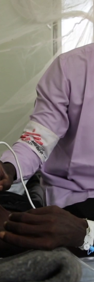 En man i munskydd behandlar en patient med tuberkulos