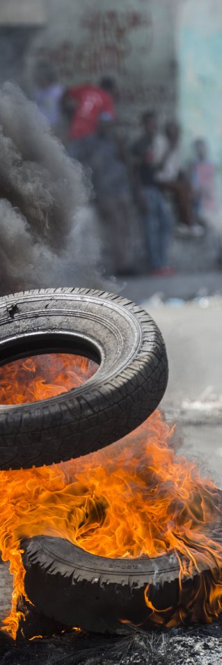 En demonstrant bränner däck i Port-au-Prince