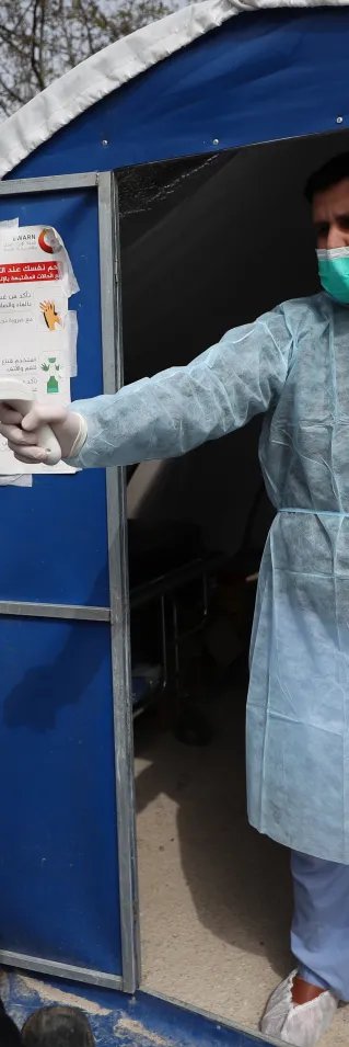 En man håller en termometer mot pannan på en kvinna