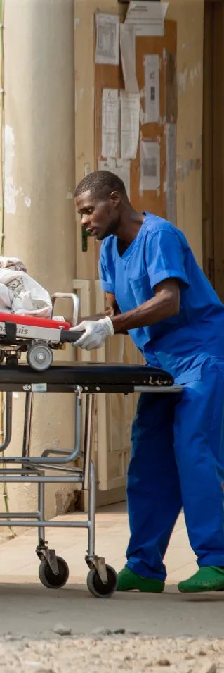 En patient på en bår lyfts in i en ambulans.