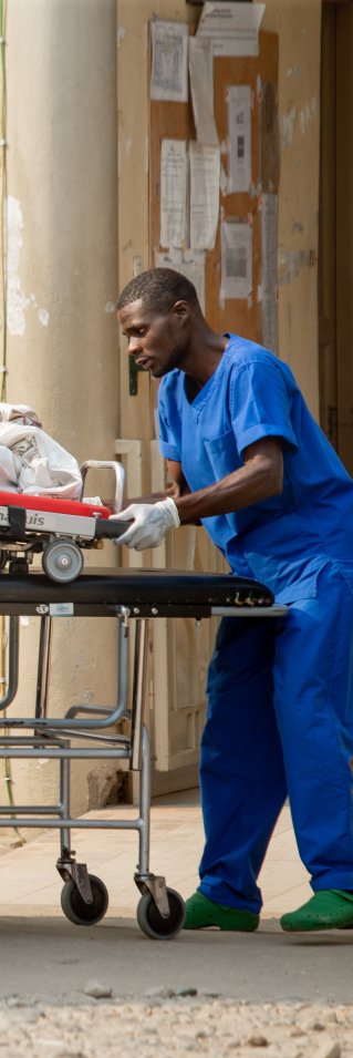 En patient på en bår lyfts in i en ambulans.