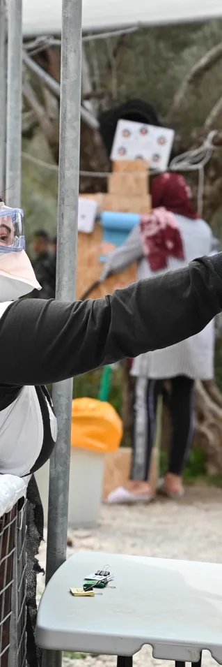 Medicinsk personal tar temperaturen på ett barn i flyktinglägret Moria, på den grekiska ön Lesbos.