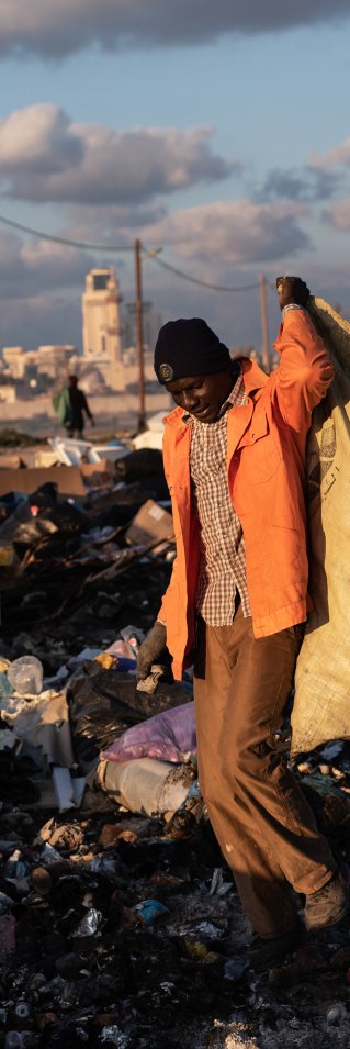 En man samlar skrot på en sopptipp i Libyen.