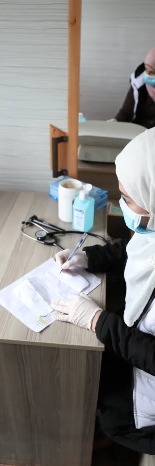 En sjuksköterska konsulterar med en ung pojke i nordvästra Syrien