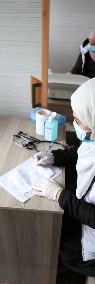 En sjuksköterska konsulterar med en ung pojke i nordvästra Syrien