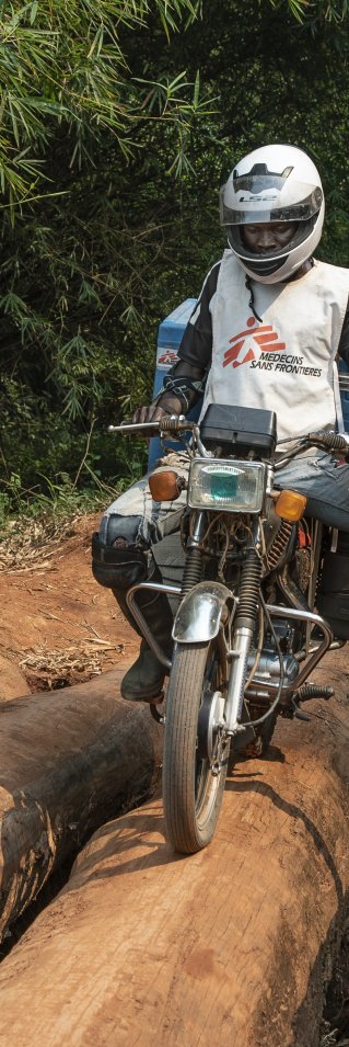 Sjukvårdspersonal på motorcyklar på en lerväg