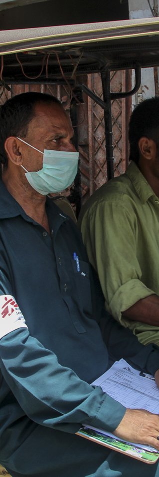 Hälsoinformatören Munir Hussain delar ut munskydd i Karachi, Pakistan, för att stoppa spridningen av covid-19.