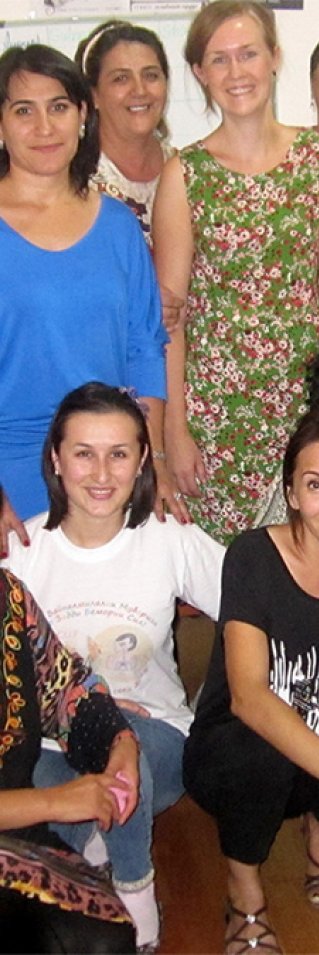 En stor grupp med kvinnliga medarbetar poserar framför kameran i sitt kontor