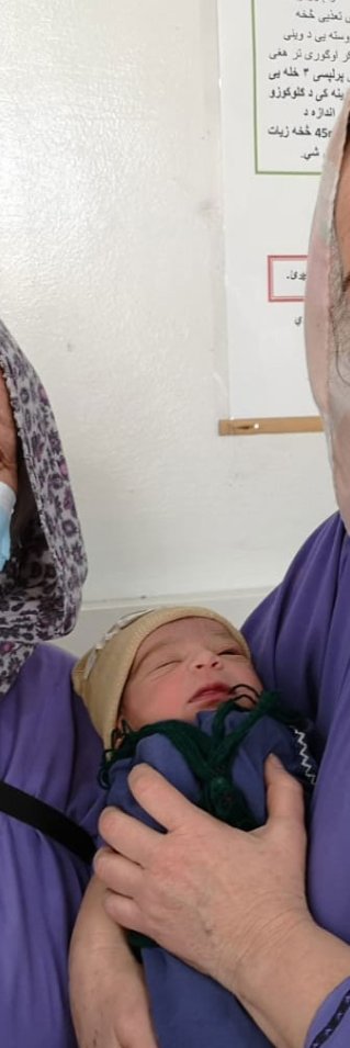 Barnmorskorna Astrid och Lena håller i en nyfödd bebis, på Khost kvinnorsjukhus i Afganistan.