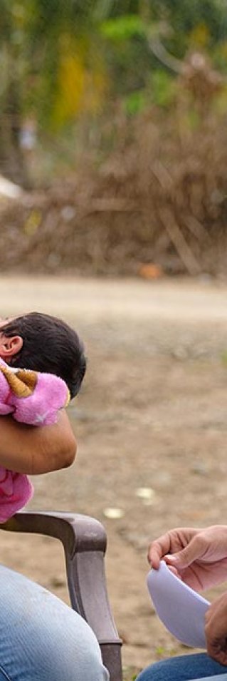 En anställd från Läkare Utan Gränser samtalar med en kvinna och hennes två barn i Choloma, Honduras.